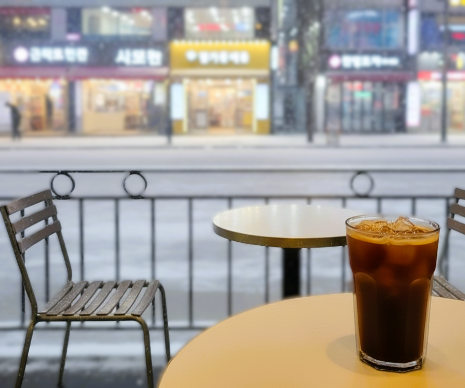 A refreshing iced Americano held against a snowy Korean winter backdrop