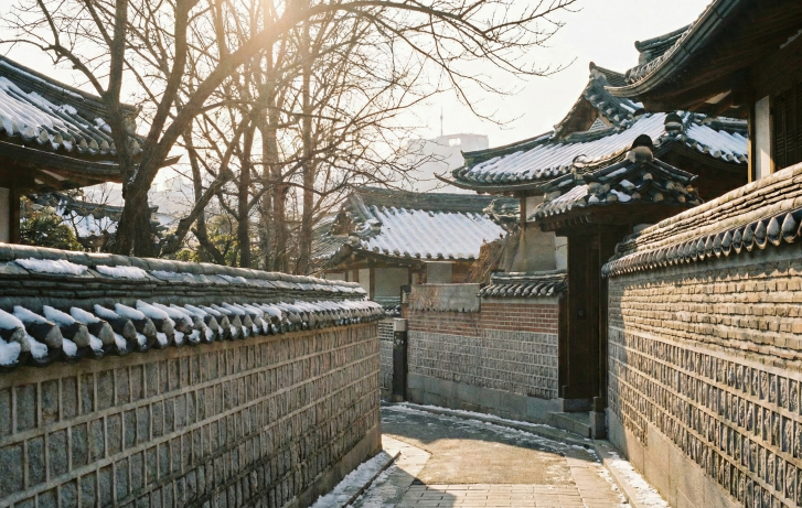 Korea weather in February scenery with a traveler walking in a snowy Hanok village