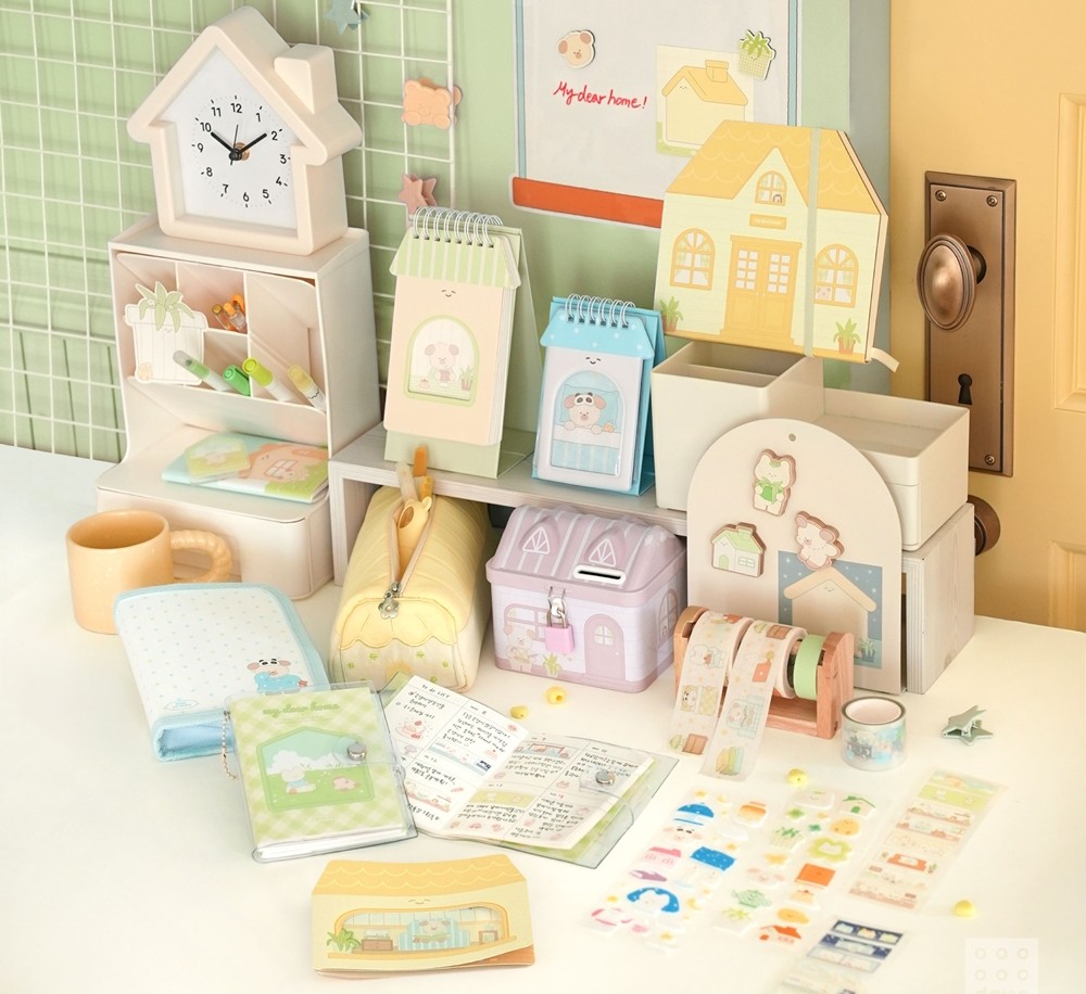A collection of cute pastel-themed Korean stationery from Daiso, including a house-shaped clock, planner, wahi tapes, and decorative stickers.